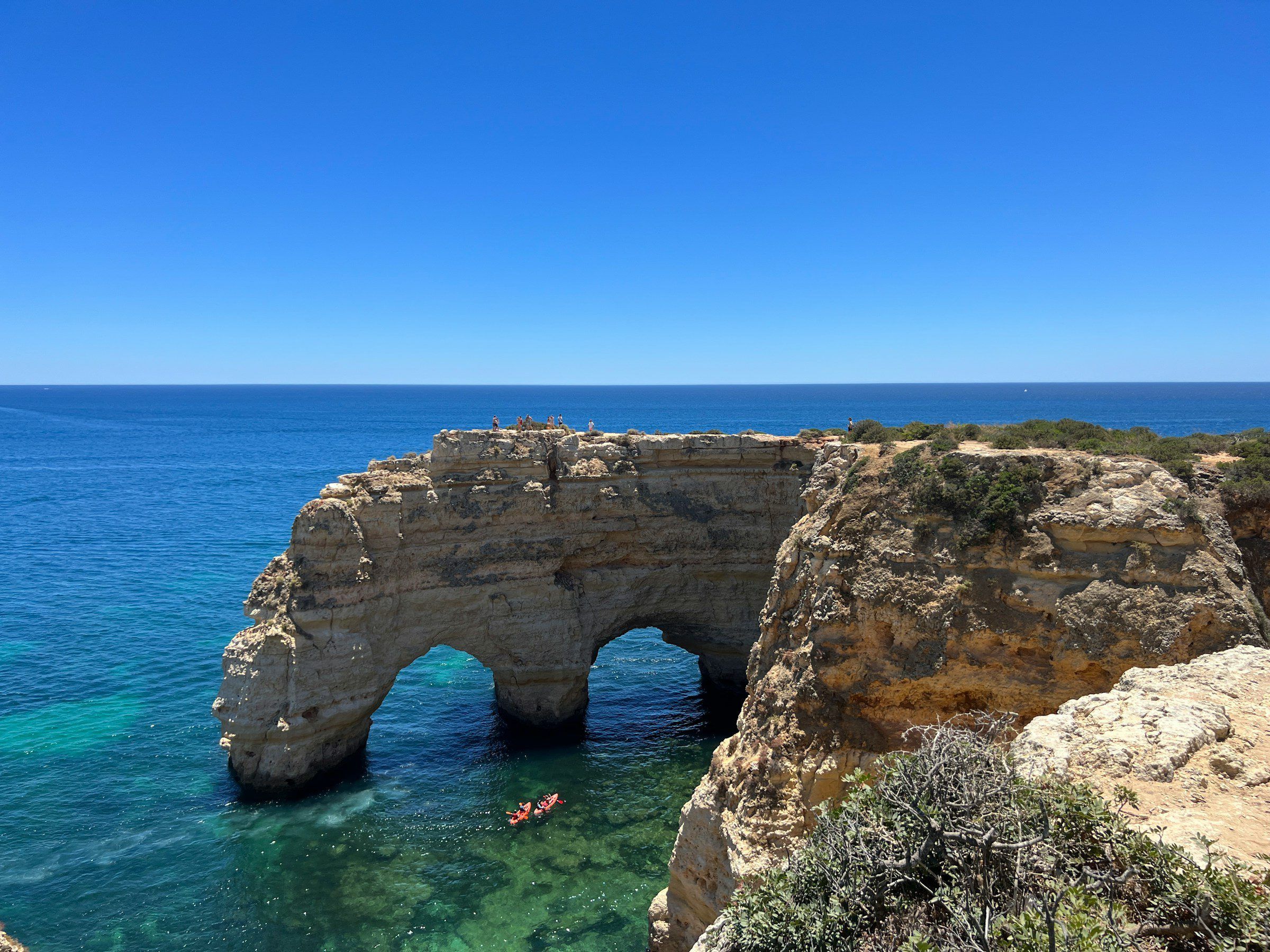 The natural double arch in the cliffs near Benagil on the Algarve coast, with kayaks in clear water below