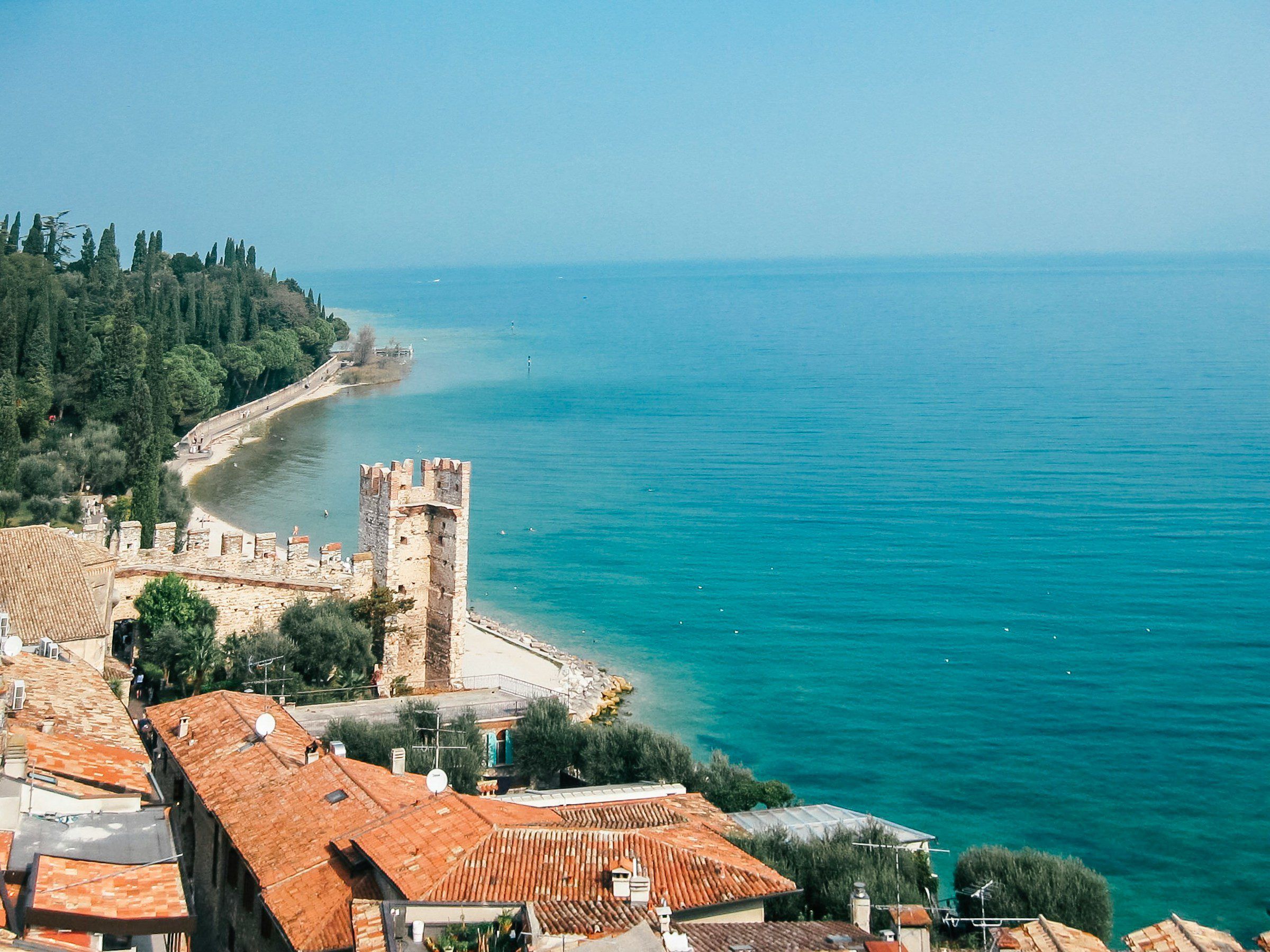 Sirmione's castle walls and rooftops beside the turquoise water of Lake Garda